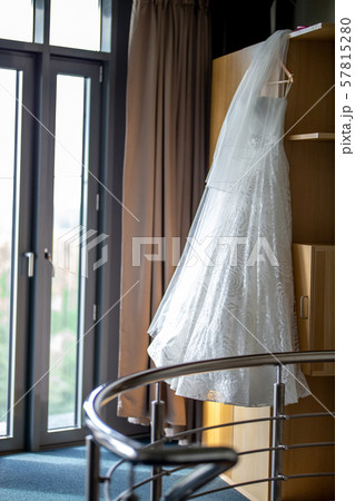 Bridal dress hanging at wooden closet 57815280