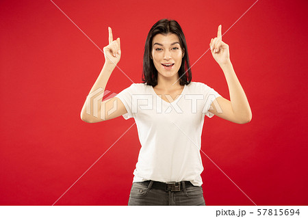 Caucasian young woman's half-length portrait on red background Caucasian young woman's half-length portrait on red background 57815694