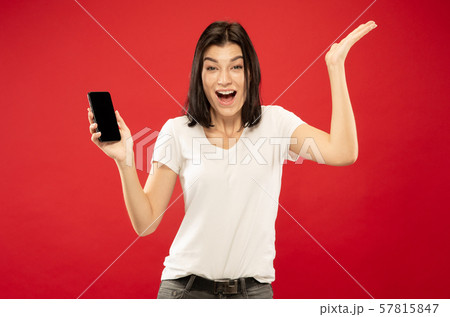 Caucasian young woman's half-length portrait on red background Caucasian young woman's half-length portrait on red background 57815847