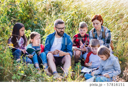Group of school children with teacher on field trip in nature. Group of school children with teacher on field trip in nature. 57816151