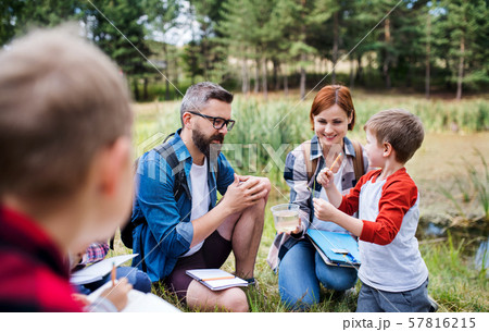 Group of school children with teacher on field trip in nature, learning science. 57816215