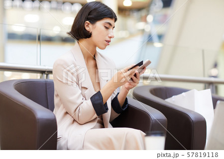 Beautiful Woman Using Mobile App in Mall 57819118