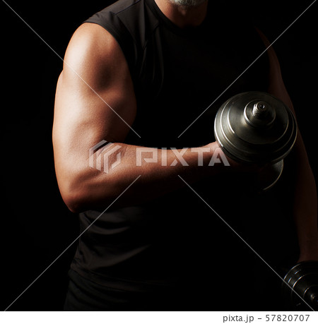 man in black clothes holds steel dumbbells in his 57820707