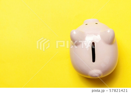 Pink piggy bank isolated on yellow background 57821421