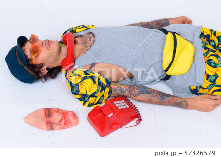 Young rebellious man with old telephone and horror mask as bizarre concept 57826579