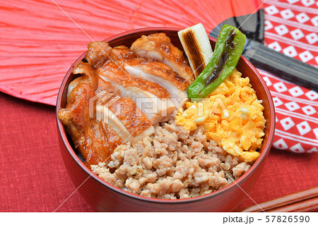 焼鳥丼 鶏モモ肉の照り焼き丼 3色丼 三色丼 テリヤキ 鶏そぼろ 炒り卵 焼きネギと焼きししとう の写真素材