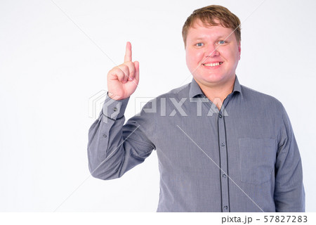 Portrait of happy overweight businessman pointing finger up Portrait of happy overweight businessman pointing finger up 57827283
