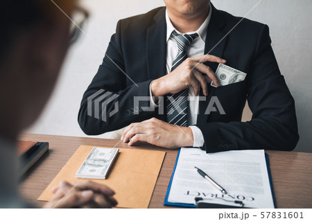 Businessman putting stack of money bills in his Businessman putting stack of money bills in his 57831601