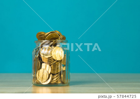 Coin money in the glass jar on table with green 57844725