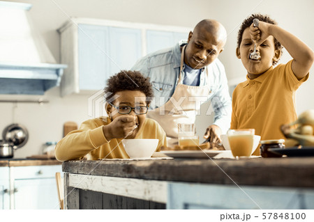 Man in an apron preparing a brunch for his sons. Man in an apron preparing a brunch for his sons. 57848100