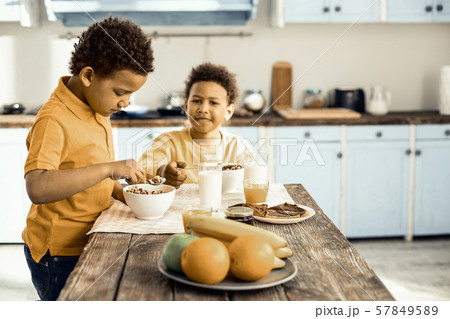 Cute Afro-American twins having breakfast before school. 57849589