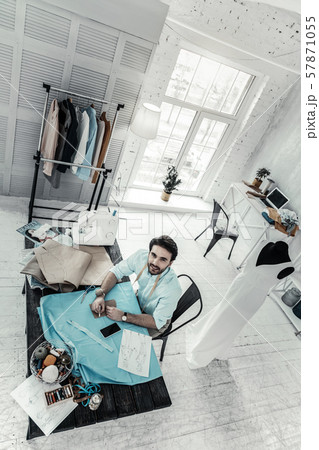 Handsome fashion designer sitting at his workplace Handsome fashion designer sitting at his workplace 57871055