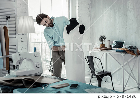 Attentive young designer preparing dress for show 57871436