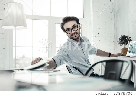 Handsome brunette man keeping smile on his face Handsome brunette man keeping smile on his face 57879700