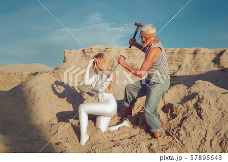 The old man makes a woman of marble. 57896643