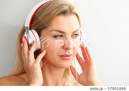 Beautiful adult woman wearing headphones listening music Beautiful adult woman wearing headphones listening music 57901888