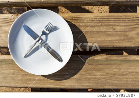 Empty plate with knife and fork Empty plate with knife and fork 57921987