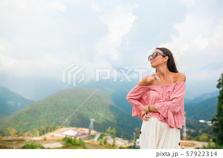 Beautiful happy young woman in mountains in the background of fog Beautiful happy young woman in mountains in the background of fog 57922314