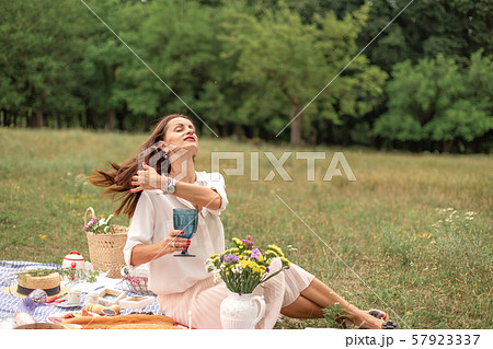 Young brunette woman enjoy outdoor picnic on green 57923337