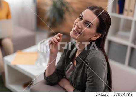 High angle of happy brunette patient is satisfied at psychology seance indoors 57924738