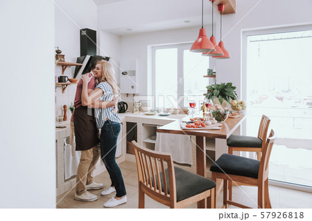 Beautiful couple in love hugging in kitchen at home Beautiful couple in love hugging in kitchen at home 57926818