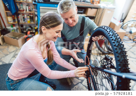 Bike Mechanic and customer looking at the bicycle that needs service 57928181