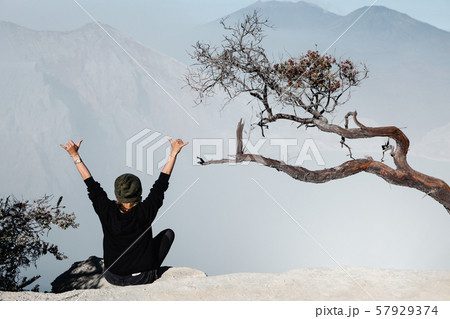 Girl sit on rock above volcano Kawah Ijen acid 57929374