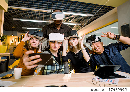 Young group of multiethnical people having fun with vr headset. Caucasian girls and man, African and 57929996