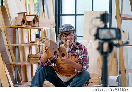 Asian old craftsman present his wood product in front of the camera  57931658