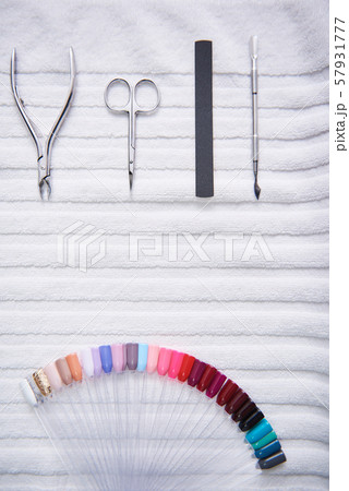 Manicure tools and nail polish color palette lying on white soft towel Manicure tools and nail polish color palette lying on white soft towel 57931777