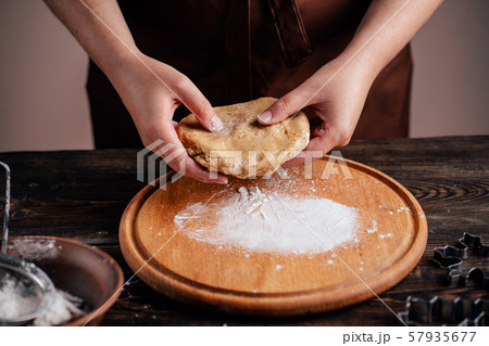 Woman kneading gingerbread dough on pastry board 57935677