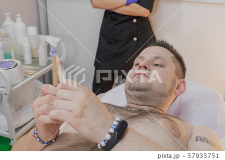 Handsome man on waxing procedure in a beauty salon 57935751