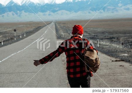Guy in red hitchhiking down on lonesome road Guy in red hitchhiking down on lonesome road 57937560