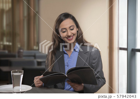 Businesswoman reading magazine on table 57942043