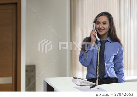 Receptionist talking on phone Receptionist talking on phone 57942052