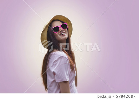 Portrait of young woman wearing hat and sunglasses 57942087