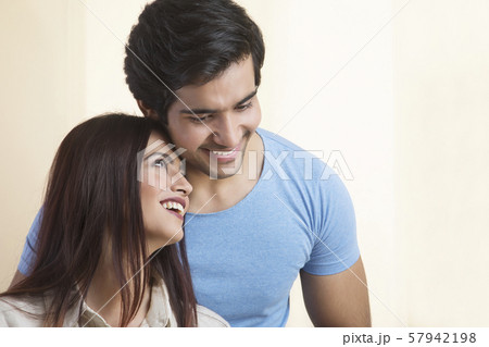 Portrait of smiling young couple hugging Portrait of smiling young couple hugging 57942198