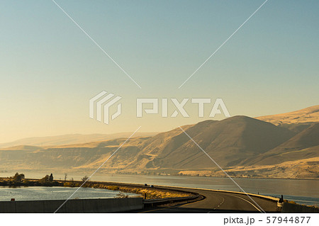 The US-30 highway passing by the Columbia River with water on both sides of the road near The Dalles 57944877