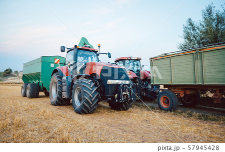 Agricultural machinery and tractor on a harvested field 57945428