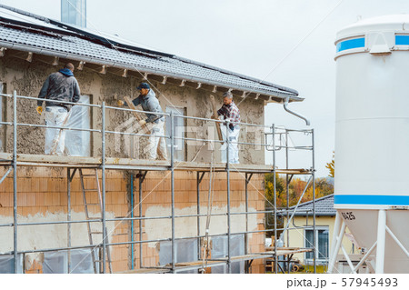 Plaster worker on scaffold working 57945493