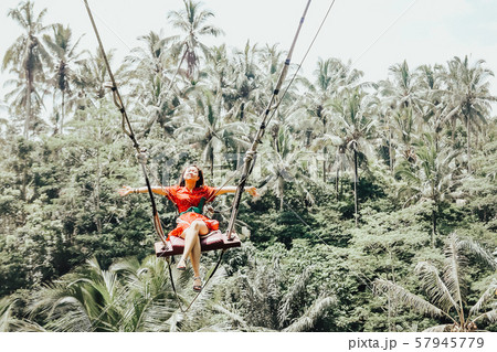 Young pretty Asian woman is swinging on the cliff Young pretty Asian woman is swinging on the cliff 57945779