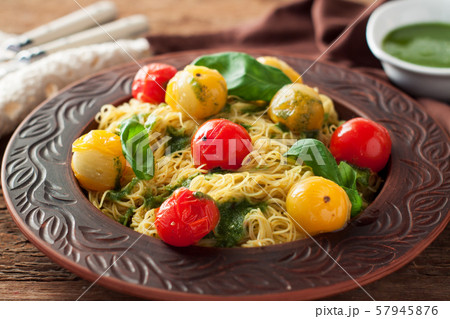 Spaghetti with stewed tomatoes, pesto, basil 57945876
