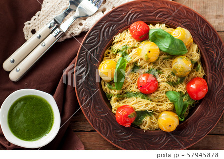 Spaghetti with stewed tomatoes, pesto, basil 57945878