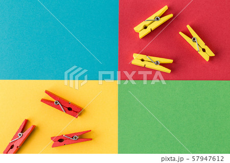 Little wooden clothespins on colorful paper background. 57947612