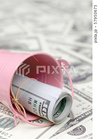 A bundle of US dollars in a metal pink bucket on a 57950675