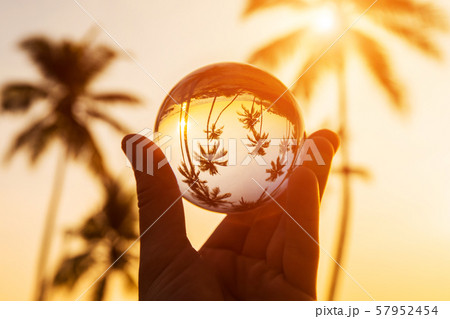 Reflection of tropical beach at sunset in a glass ball. 57952454