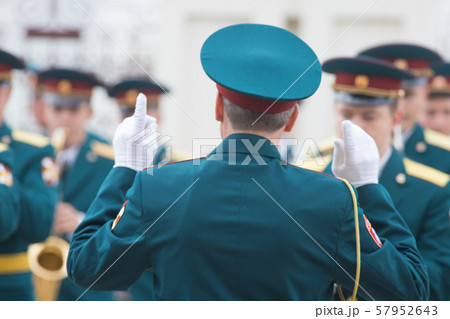 A wind instrument parade - people in green costumes listening to the conductor 57952643