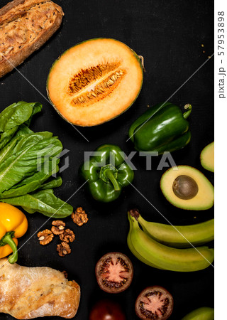 Different vegetables and baguette on a black background. Vegan healthy food 57953898
