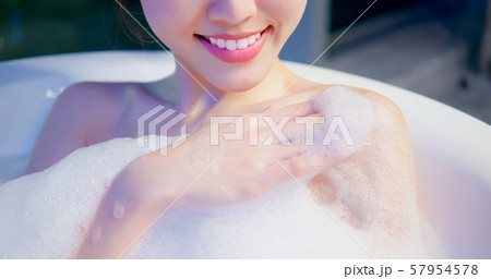 young woman taking a bath young woman taking a bath 57954578