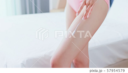 woman apply cream with leg woman apply cream with leg 57954579